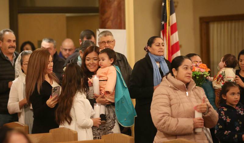 Families light candles during the Lady of Guadalupe event on Tuesday, Dec. 12, 2023 at St. Hyacinth Church in La Salle. Our Lady of Guadalupe, also known as the Virgin of Guadalupe, is a Catholic title of Mary, mother of Jesus.k