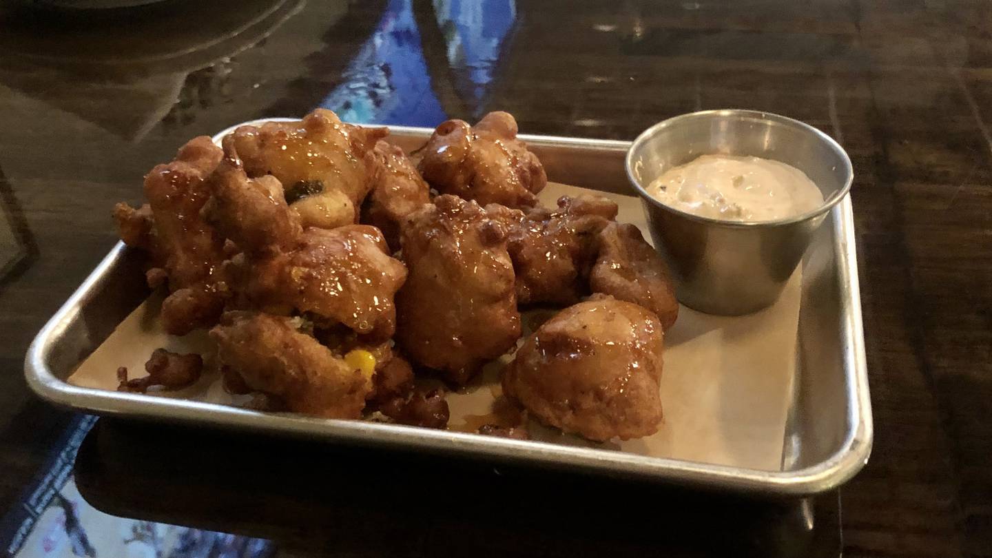 Corn fritters with poblano peppers, hot honey, and BUCK sauce at Six19 Restaurant + Bar in Plano..