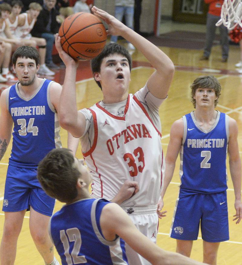 Ottawa’s Cooper Knoll eyes the basket over Princeton’s Tyson Phillips in the 2nd period in Kingman Gymnasium on Saturday, Jan. 21, 2023 at Ottawa High School.