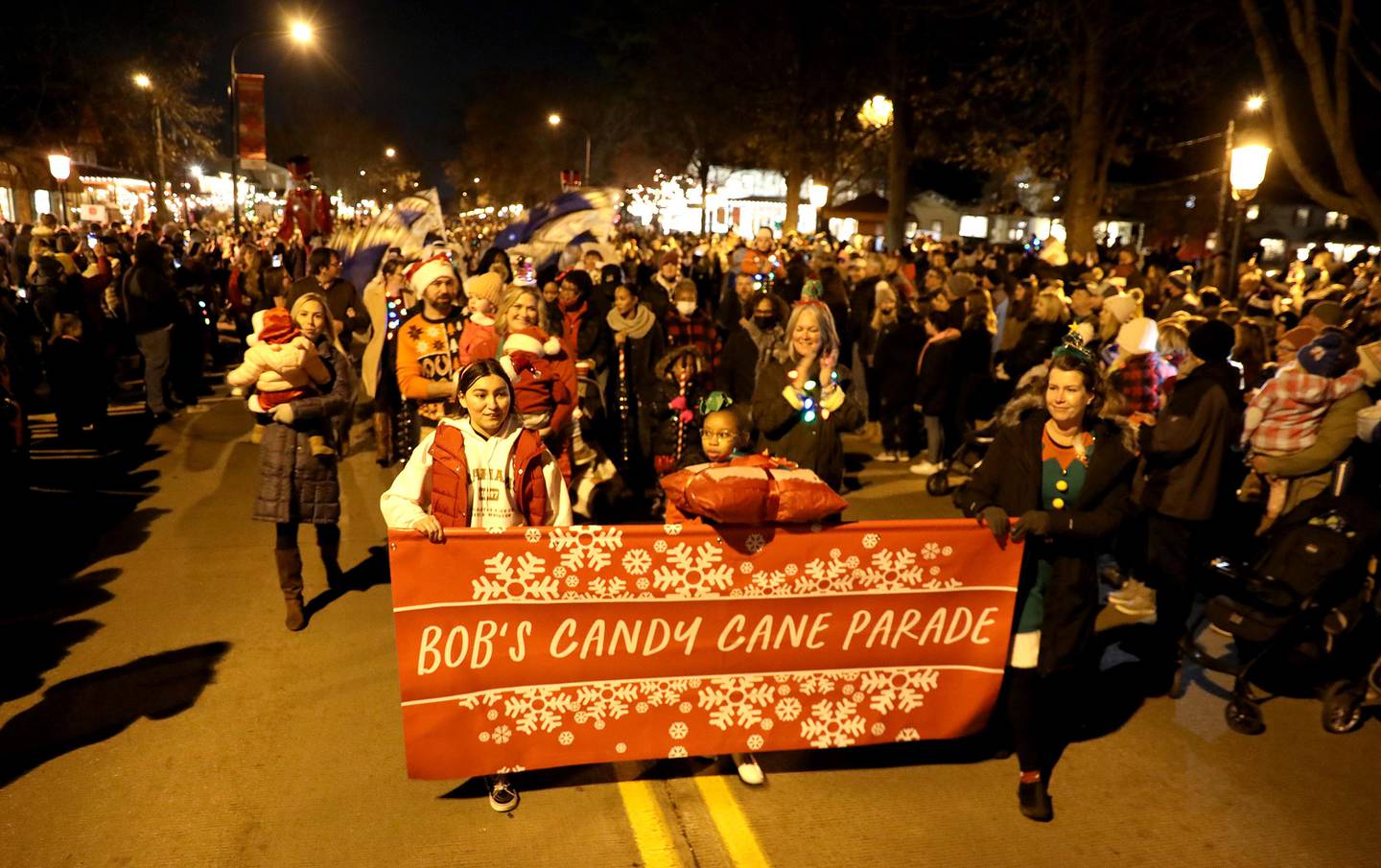 The first candy cane from Graham's is paraded down Third Street in Geneva during the Geneva Christmas Walk on Friday Dec. 3, 2021.