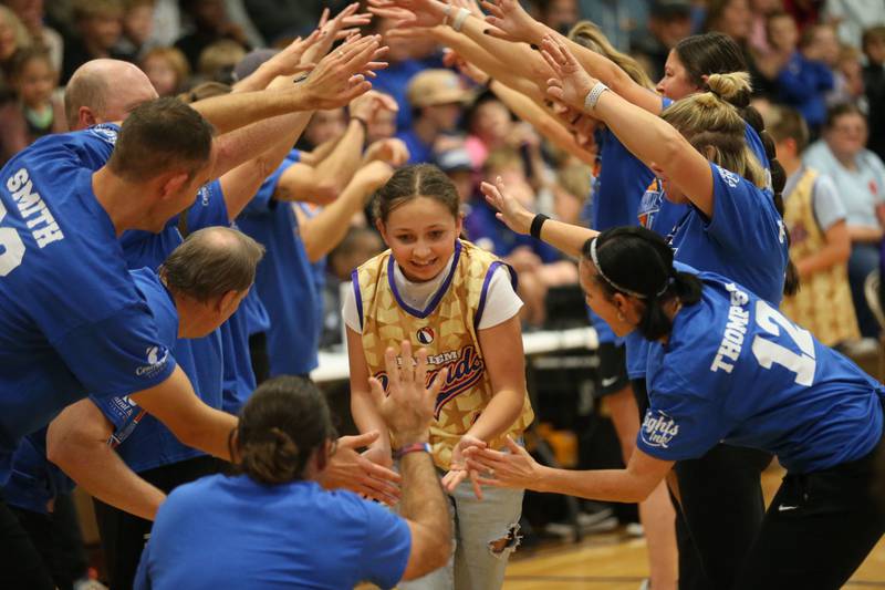 Brielle Faber, a seventh-grade student at Logan Jr. High School, runs through a tunnel of teachers during the Harlem Wizards event on Tuesday, Oct. 28, 2025 in Pannebaker Gymnasium at Logan Jr. High School in Princeton.