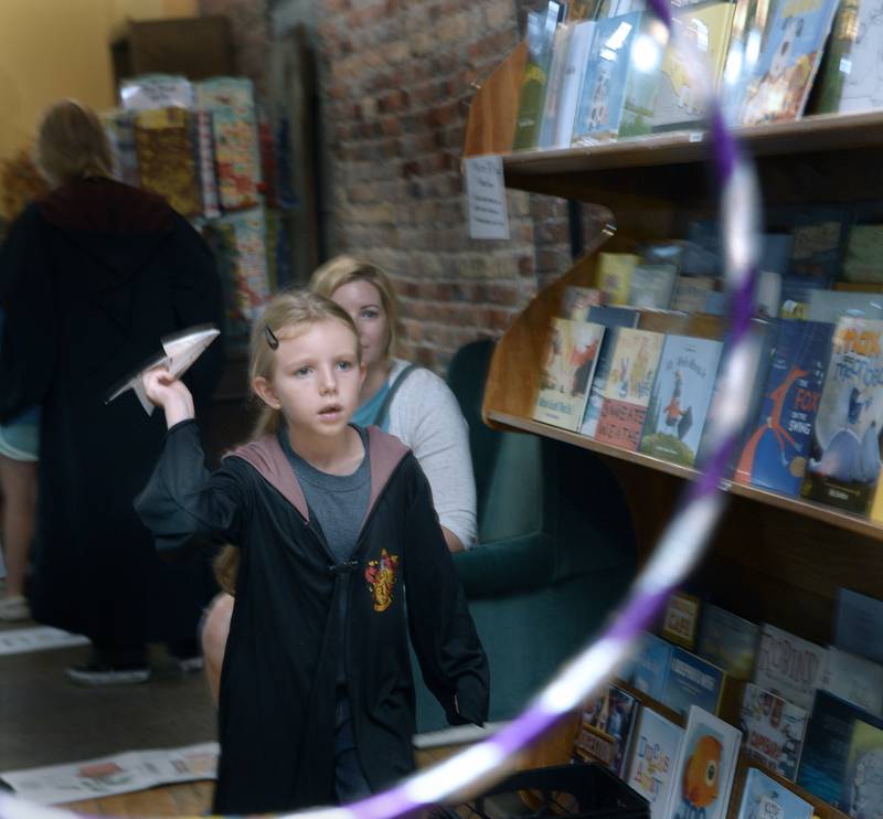 Millicent Segovich prepares to throw and get through a hoop a paper airplane during one of the many games Saturday, July 29, 2023, during the fifth annual Harry Potter Birthday Bash at Prairie Fox Books in Ottawa.