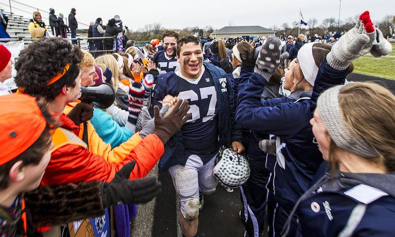 Cary-Grove's Michael Gomez (center) and Trevor Ruhland lead their team through a tunnel of fans after beating Geneva in the Class 7A football quarterfinal game Saturday in Cary. Cary-Grove beat Geneva, 44-26.