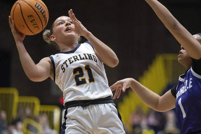 Sterling’s Jae James works below the basket against Rochelle’s Carmela Bright Monday, Feb. 17, 2025, during the girls 3A regional semifinal game in Sterling.