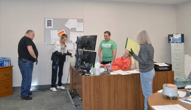 Rock Falls Police Department Citizen Police Academy participants Brent Wright (left), Valerie Villaneda and Jodi Perez (far-right) looks over a mock crime scene with Detective Sgt. Doug Wolber (center) during the group's April 3, 2024, meeting. The "victim" is played by police Officer Autumn Day.