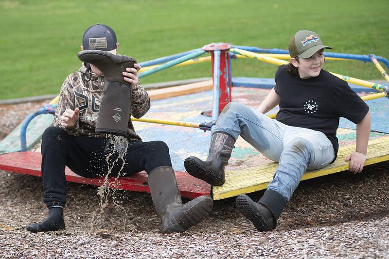 Connor Fritz, 11, drains his boot after working to pick up trash at Centennial Park Saturday, April 23. 2022. The Rock River Development Authority organized a day of cleaning along the canal in recognition of Earth Day.