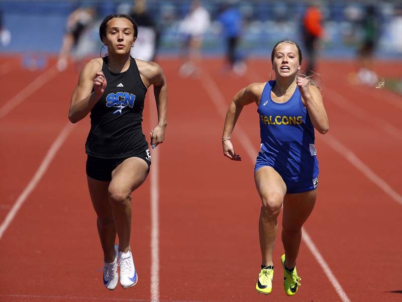 Alexzandria Richardson of St. Charles North and Autumn Gruenwald of Wheaton North compete in the 100 Meter at the St. Charles North Girls Invitational Saturday, April 12, 2025 in St. Charles Ill.