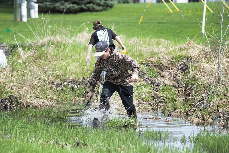 Connor Fritz, 11, wades through deep water at Centennial Park on Saturday while helping to clean up the area with the Rock River Development Authority.