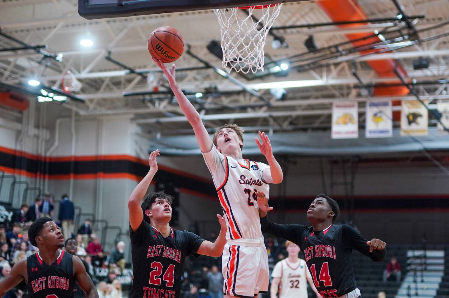 St. Charles East's Andrew Wolfsmith (24) shoots the ball in the post against East Aurora's Luis Umana (24) and Ryan Robinson (14) during the 64th annual Ron Johnson Thanksgiving Basketball Tournament at St. Charles East High School on Monday, Nov 20, 2023.