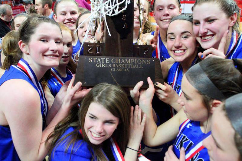 Members of the Geneva girls' basketball team celebrate with their championship trophy March 4 after a 41-40 win against Edwardsville in the Class 4A state final. on Saturday evening. The Vikings won their first state title in program history after finishing fourth in their previous two state trips.