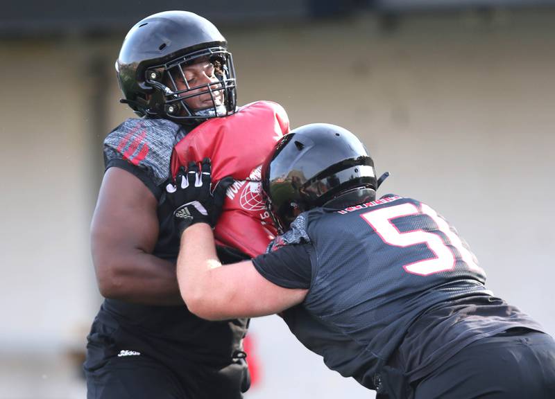Northern Illinois Huskies defensive tackle James Ester (left) and defensive tackle Cade Haberman work in a drill at the teams first practice of the season Wednesday, Aug. 2, 2023, at Huskie Stadium in DeKalb.
