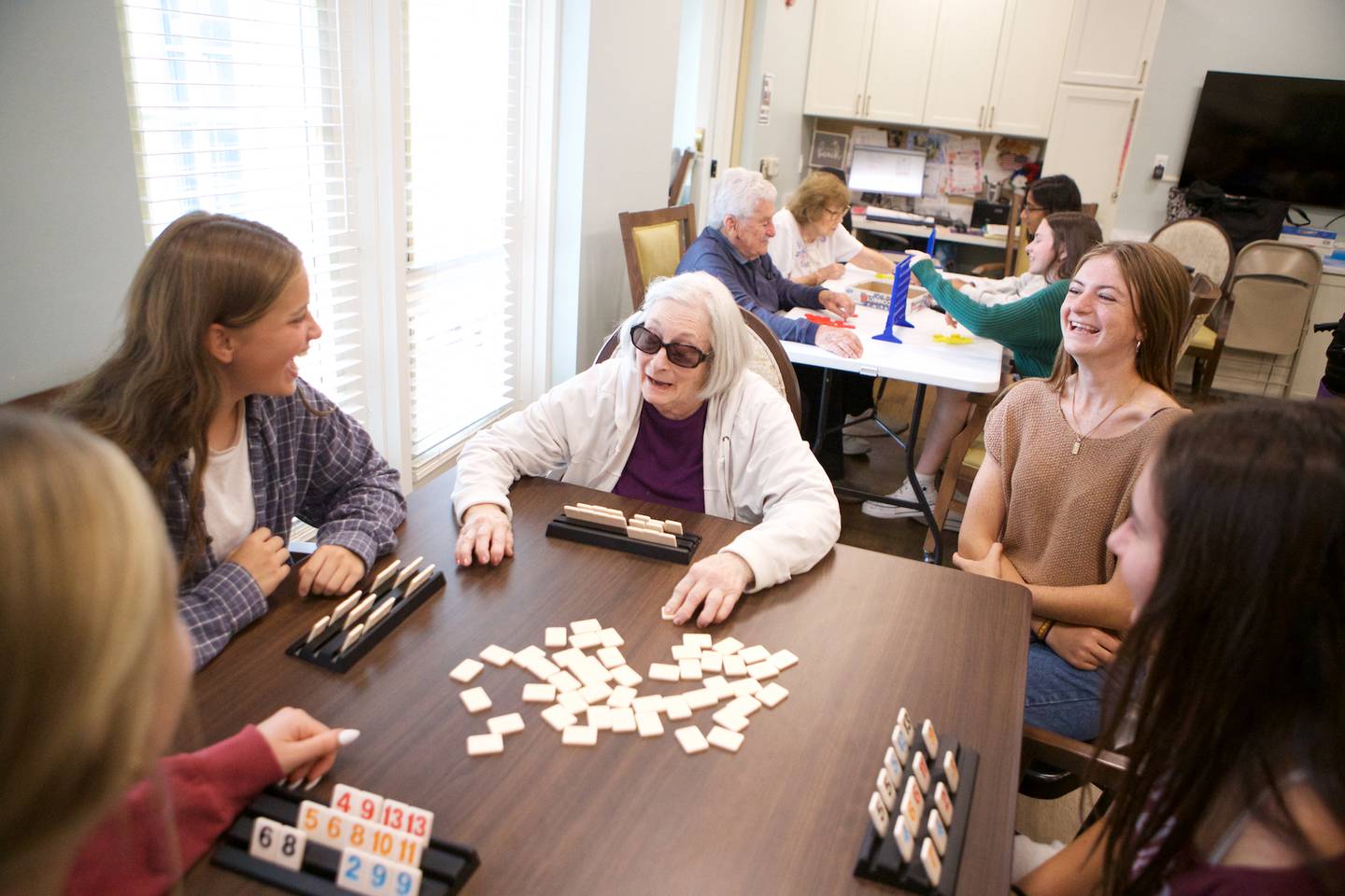 Reese Thomas laughs with fellow students and residents during Connect More Club event by District 303 students at Brighton Gardens on Sunday, Sept.21,2025 in St. Charles.
