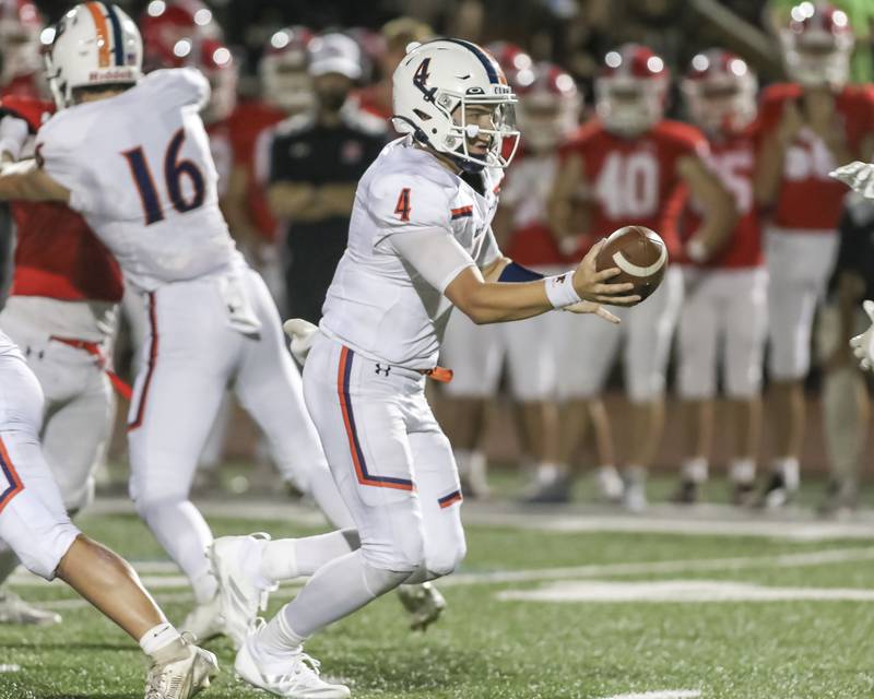 Oswego's Drew Kleinhans (4) hands off during football game between Oswego at Naperville Central  on Friday, Aug 29, 2025  in Naperville.