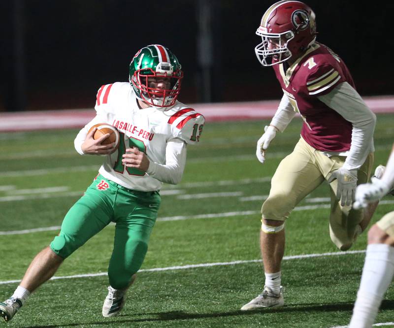 L-P's Brady Romagnoli (13) runs the ball past Morris's Jonah Williams (7) during the Class 5A round one football game on Friday, Oct. 28, 2022 in Morris.