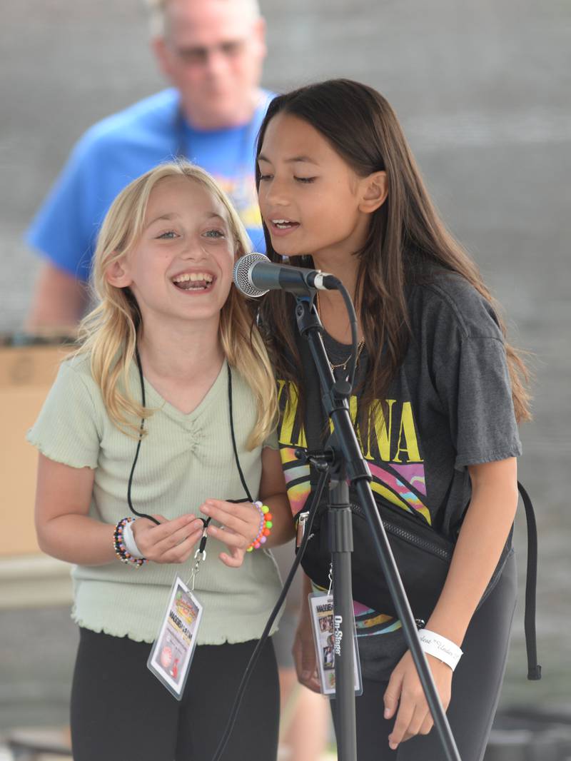 (left) Natalie Duncan and Mai Sesta of Plainfield sing a Taylor Swift song while karaokeing at the Downers Grove Octoberfest Saturday, Sept. 16, 2023.