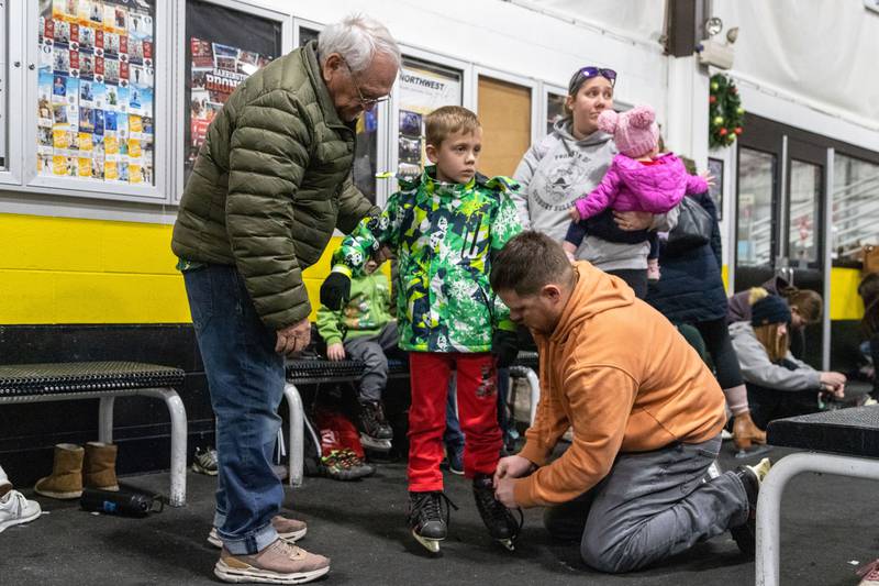 Kevin Sample, right, and Clyde Sample, left, help Andrew Sample, 7, with his skates during open skate at Crystal Ice House in Crystal Lake on Friday, Jan. 3, 2025.