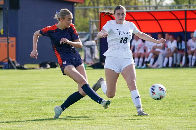 Oswego’s Gianna Rizzo (8) shoots the ball against Oswego East's Keelan Quick (18) during a soccer match at Oswego High School on Tuesday, April 29, 2025.