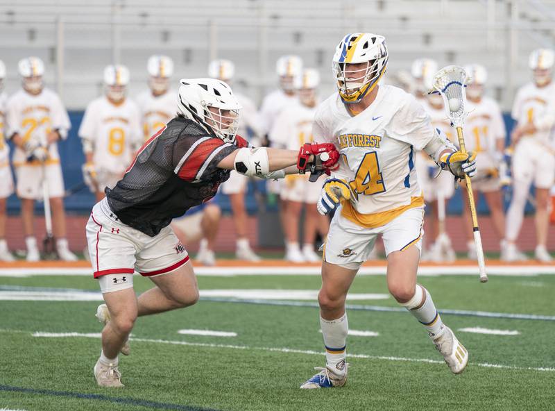 Huntley defender Brady Mollsen puts pressure on Lake Forest's Michael Cassidy during the boys lacrosse supersectional match on Tuesday, May 31, 2022 at Hoffman Estates High School.