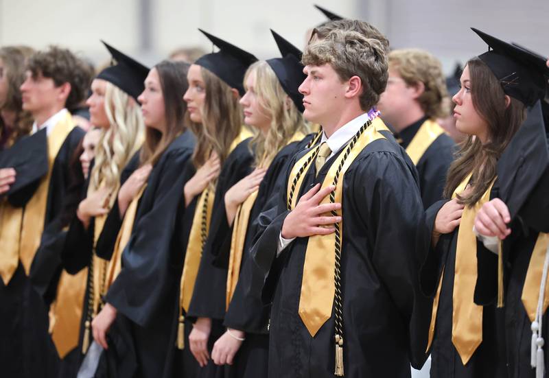 Graduation candidates rise for the National Anthem during commencement ceremonies Sunday, May 28, 2023, at Sycamore High School.