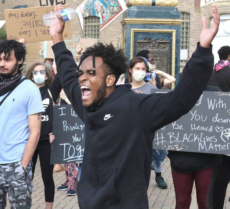 Andre Allen Jr., from DeKalb, leads a chant Monday during a protest against police brutality at Memorial Park in DeKalb.