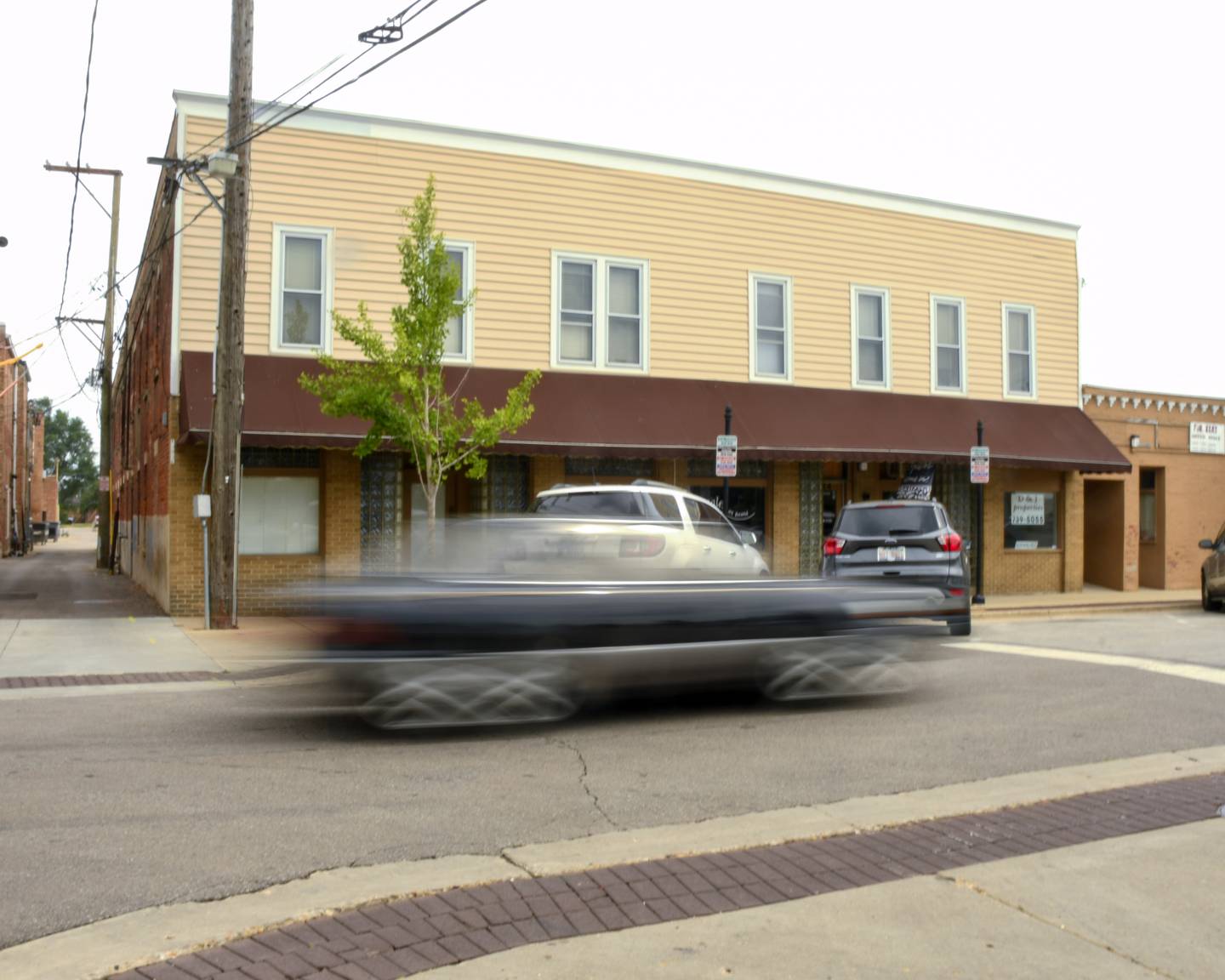 On Wednesday July 5, 2023 a car passes a 133 year old building on 2nd Street in DeKalb that has been talked about being torn down for a parking lot.