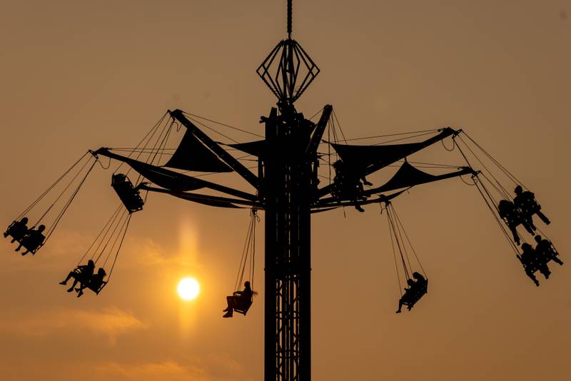 Carnival ride goers swing during a portion of their ride against the summer evening sky at Streator Fest on August 1, 2025.