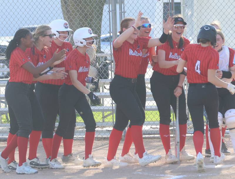 Members of the Henry-Senachwine softball team greet teammate Alaina Sprague at home plate after hitting a home run against Marquette on Thursday, April 23, 2026 at June Cross Field in Ottawa.