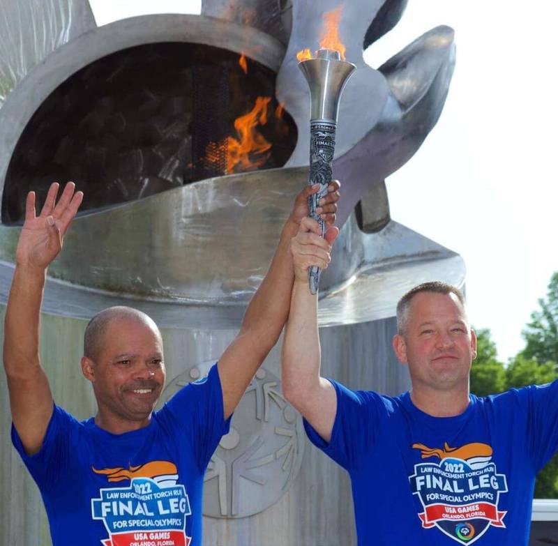 Algonquin Police Chief Dennis Walker, right, and Illinois Special Olympics athlete Aaron Drescher light the Torch of Hope outside Soldier Field in 2022 to begin the final leg of the Law Enforcement Torch Run for the 2022 Special Olympics USA Games.