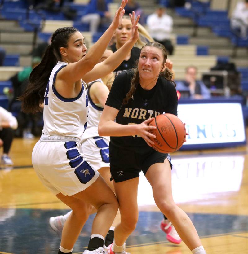St. Charles North’s Katrina Stack looks for a shot under the defense of Geneva’s Leah Palmer during a game at Geneva on Tuesday, Feb. 6, 2024.