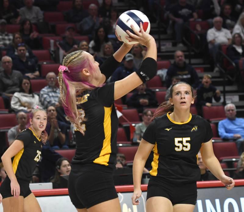Riverdale's Cayleigh Hungate (12) sets the ball as Kenadie Willemkens (25) and Katie Cox (55) move into position during the 2A semifinal match with Central Catholic at the state volleyball tournament at Illinois State University on Friday, Nov. 14, 2025.