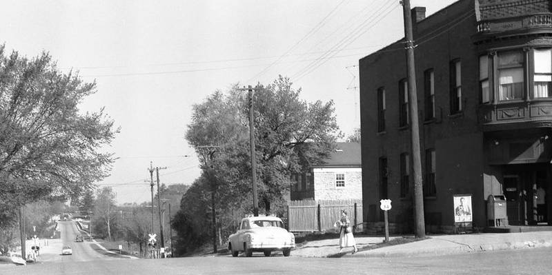 Dorothea Ekstrom (right) crosses Washington Street (Route 34) at Main Street in downtown Oswego.The photo was taken by Homer Durrand in the spring of 1958 as part of a series he took for the upcoming Oswegorama 125th birthday of Oswego.