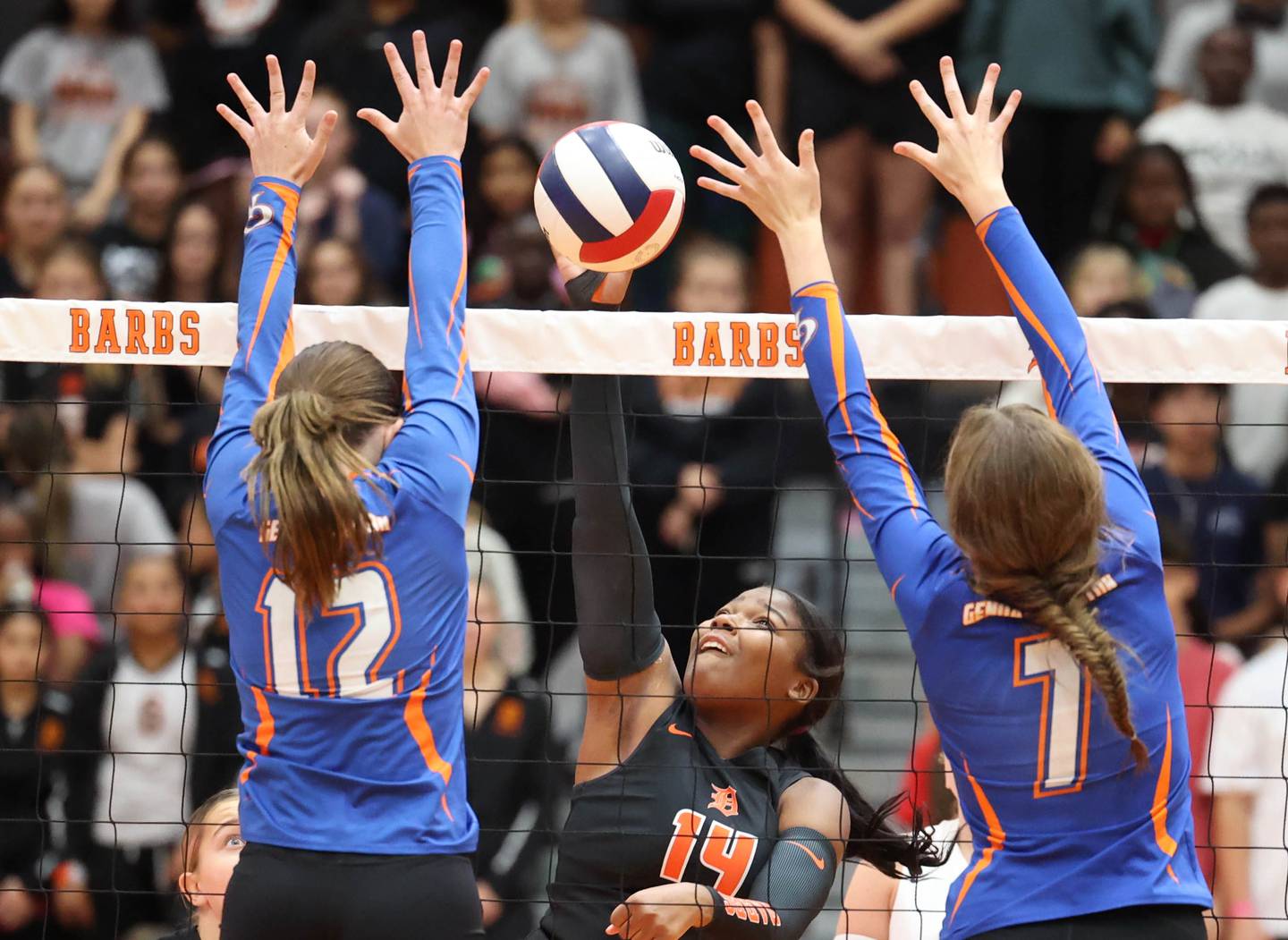 DeKalb's Jordan Grant tries to spike the ball between Genoa-Kingston's Jessie Fredrickson (left) and Katelyn O'Carroll during their match Wednesday, Sept. 10, 2025, at DeKalb High School.