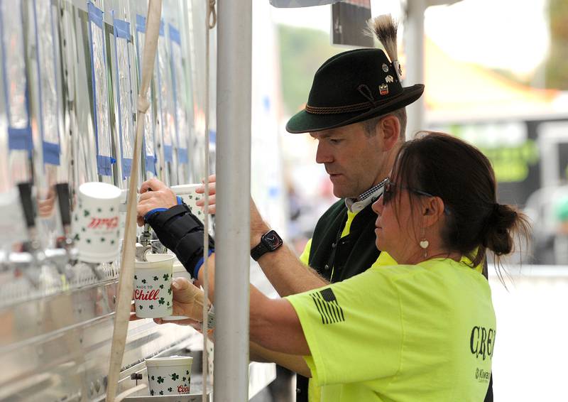 Volunteers Renee Kryger and Mark Anderson pour beers at Renee's Brauhaus during Yorktoberfest, Saturday, Sept. 28, 2024, in Riverfront Park in Yorkville.