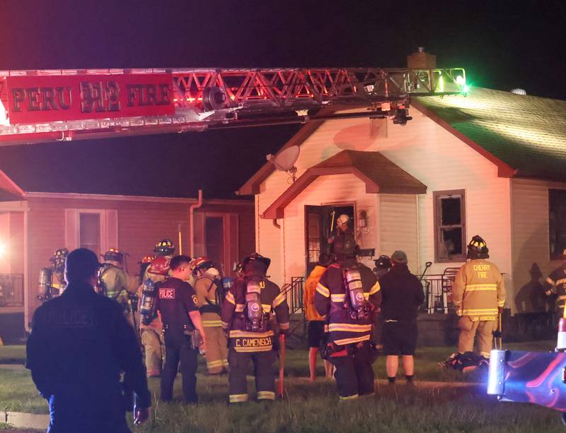 Firefighters gather around a home in the 500 block of West Erie Street for a structure fire on Monday, May 4, 2026 in Spring Valley. The fire happened shortly before 10:45p.m. A Mutual Aid Box Alarm System (MABAS) call was dispatched for additional fire departments from Eastern Bureau County, Peru, Utica, Oglesby and La Salle.