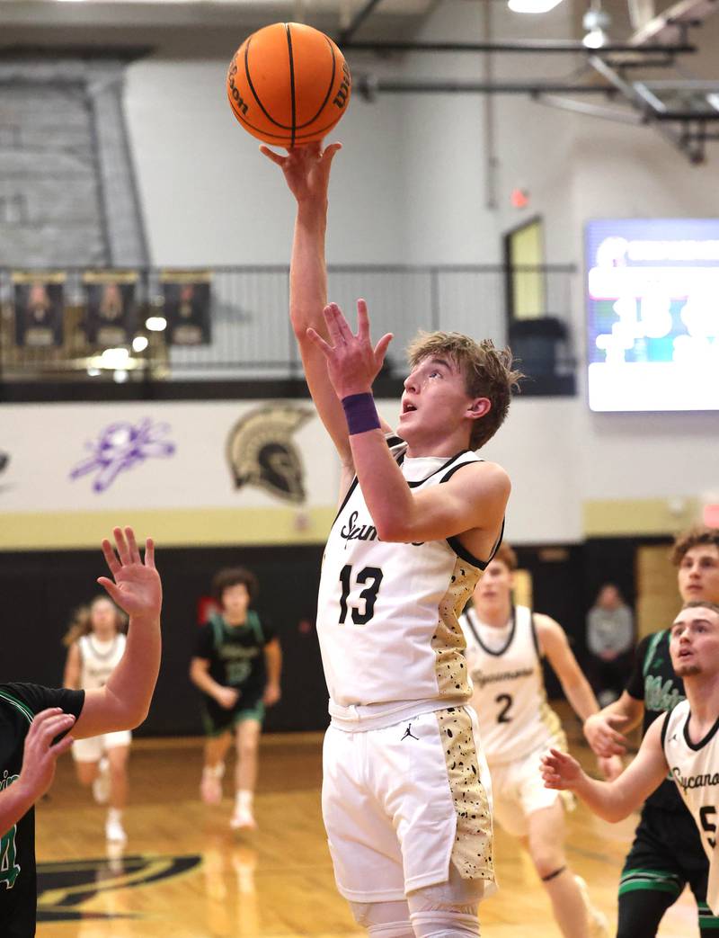 Sycamore's Xander Lewis gets a layup over North Boone's Joey Belvedere during their game Tuesday, Dec. 3, 2024, at Sycamore High School.