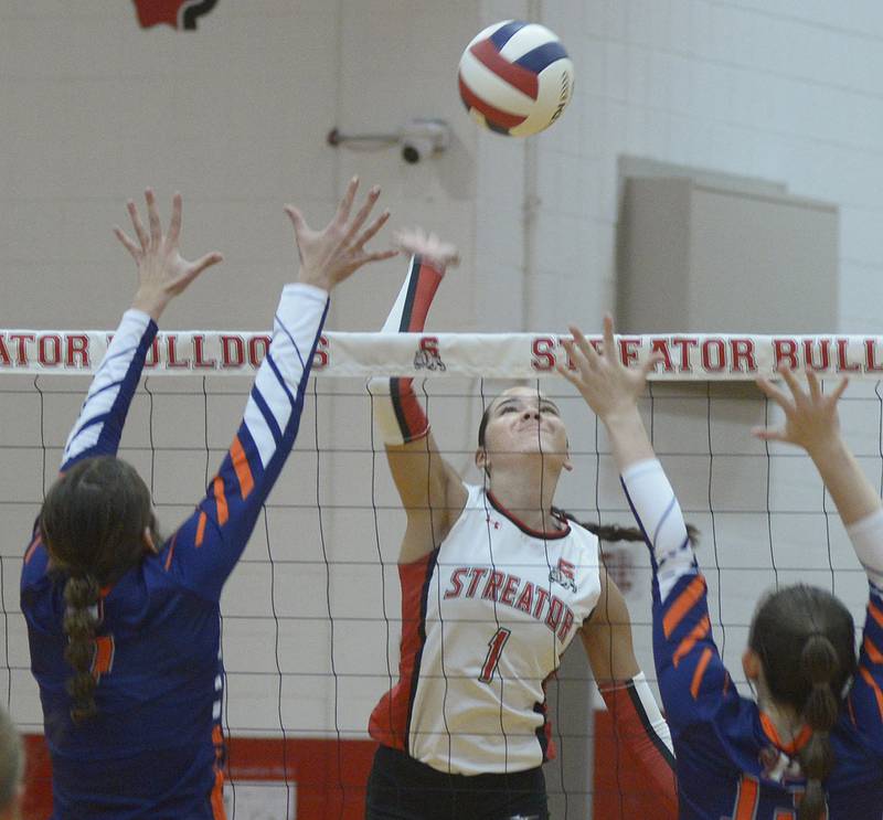 Streator’s Aubrey Jacobs sets to get the ball past the blocks of Pontiac’s Trinity Cheek and Sophia Karr in the first set Wednesday at Streator.