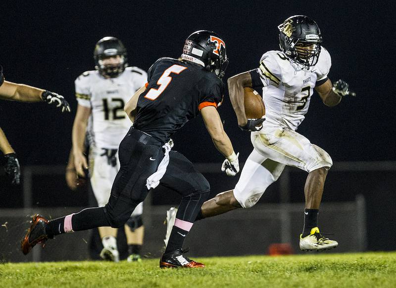 Grayslake North's Titus Booker outruns Crystal Lake Central's Bradley Garber (5) during the second quarter of the boys football game Thursday in Crystal Lake. Crystal Lake Central beat Grayslake North, 37-34.