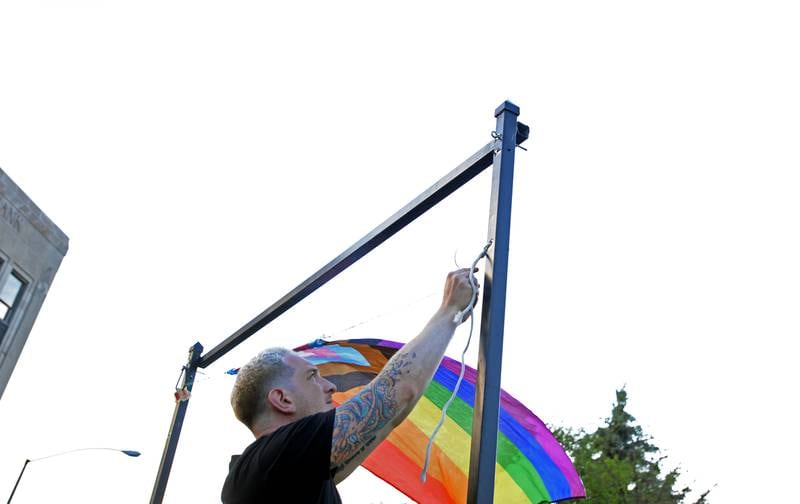 Joseph Klomes of Berwyn replaces the former banner hung at the corner near the Metra station with an all inclusive flag during the Pride rally held Tuesday June 8, 2021. The rally included a walk to the Town Hall to address council members.