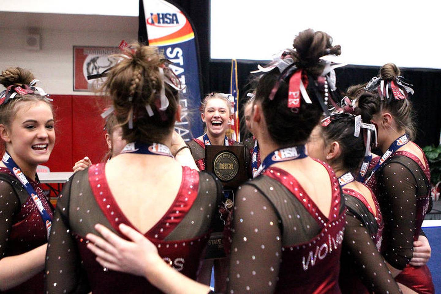 The Prairie Ridge co-op girls gymnastics team celebrates its first-place finish during the 2020 IHSA State Gymnastics Finals at Palatine High School on Feb. 22.