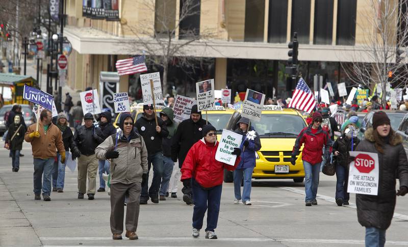 FILE - Pro-union protesters march around the Wisconsin state Capitol in Madison, Wis., March 26, 2011. With U.S. union ranks swelling as everyone from coffee shop baristas to warehouse workers seeks to organize, Illinois voters will decide in November 2022 whether to amend their state constitution to guarantee the right to bargain collectively. (AP Photo/Andy Manis, File)