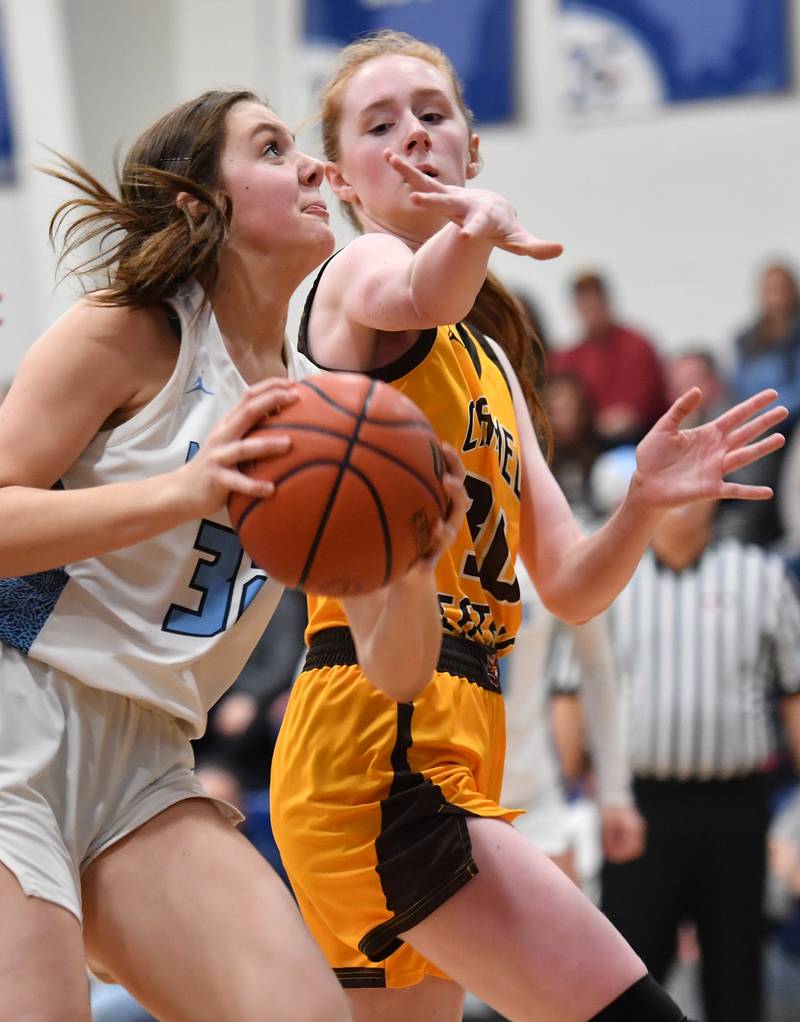 Nazareth's Stella Sakalas (left) goes to the basket as Carmel's Keira Ackerson defends during the ESCC conference tournament championship game on Feb. 4, 2023 at Nazareth Academy in LaGrange Park.