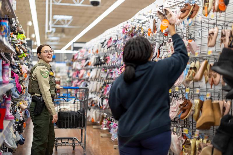 Lee County officer Alyscia Settles strolls the shoe aisle with her 14-year-old shopper during the annual Shop with a Cop event at the Dixon Walmart on Saturday, December 14, 2024.