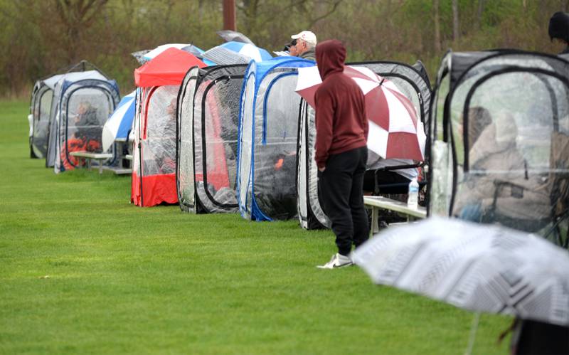 Spectators at the Oregon vs. Byron soccer came in Byron Thursday, April 18, 2024 brought their rain gear and shelters during the rain-filled game on the soccer field at  Byron High School. The Tigers won the game 2-1.