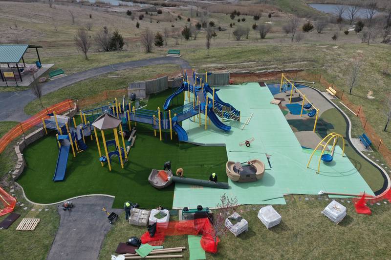 A crew from Teim Reil Inc. install new artificial turf at the playground at Rotary Park on Monday, March 18, 2024 in La Salle. The playground will be re-surfaced and completed on March 25. The playground will be closed until work is finished.