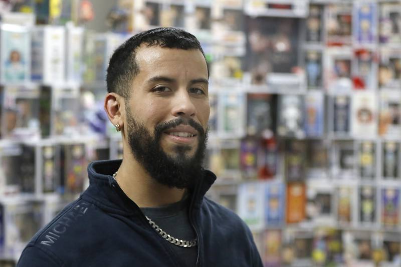 Andrew Rios, the owner of Andy’s World, on Wednesday, Feb. 5, 2025, inside his store in the Woodstock Square Mall. The store sells Funkos, charms for  CR0CS, metal pins, and posters.