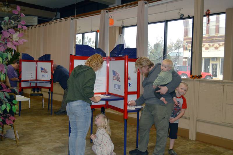 Polo residents Crystal Green (left) and Nathan Green fill out their ballots Tuesday, Nov. 5, 2024, in the Polo Area Senior Center while their kids, Arthur, 6, Lucy, 4, and Mabel, 1, wait.