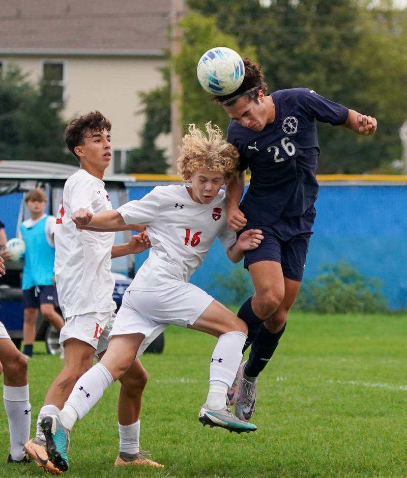 Oswego East's Josh Lopez (26) heads the ball over Oswego’s Shawn Stogentin (16) during a soccer match at Oswego East High School on Tuesday, Sept. 26, 2023.