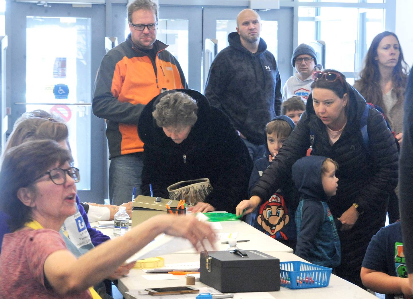 Supporters lineup at the sign-in table during the Friends of the Yorkville Library's annual Mini Golf FUN Raiser on Sunday Feb. 5, 2023.