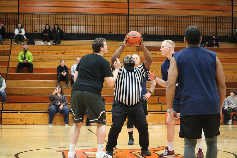 The Guns and Hoses and DeKalb District 428 faculty tip off at center court Monday, Dec. 5, 2022 in the Toys for Tots community basketball game.