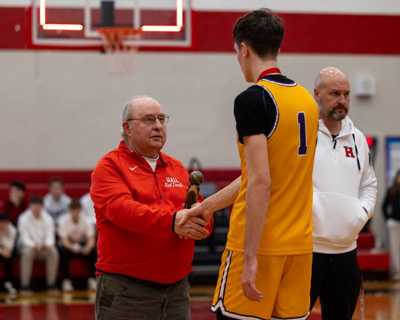 Frank Colmone awards Cole Tillman (1) of Mendota tournament MVP trophy following Mendota's win in the championship game of the Colmone Classic on Saturday, December 20, 2025 at Hall High School in Spring Valley.